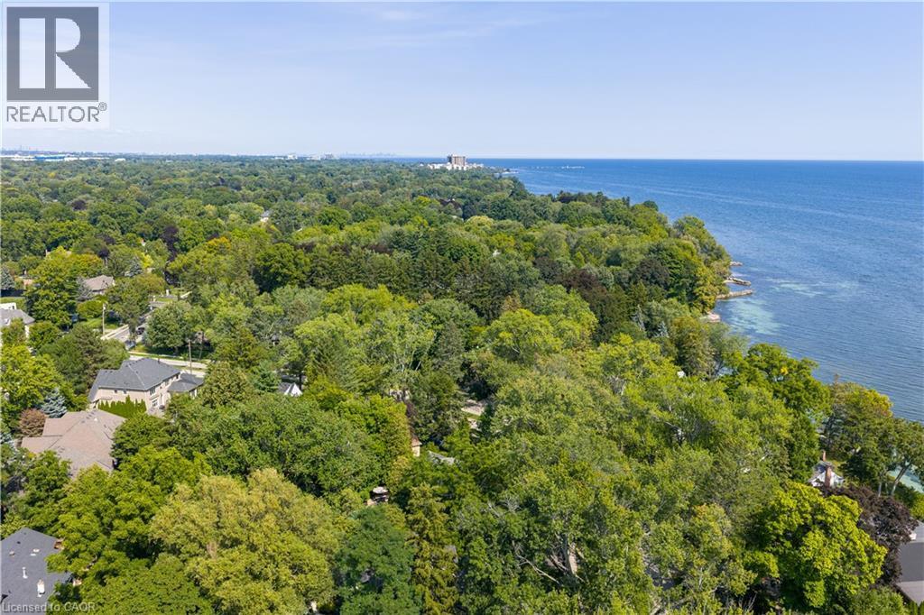 Expansive water body, lush tree canopy, surrounding residential structures, clear sky - 4189 Inglewood Drive, Burlington, ON - Outdoor With Body Of Water With View