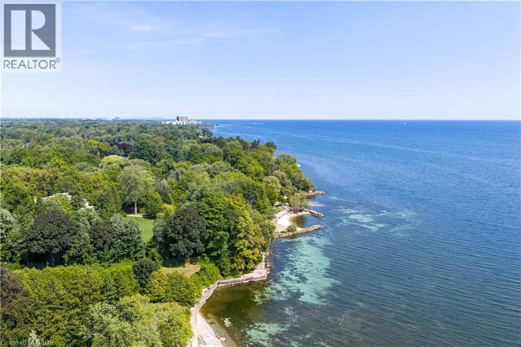 Expansive waterfront setting featuring lush mature trees, clear blue water, and a tree-lined horizon - 4189 Inglewood Drive, Burlington, ON - Outdoor With Body Of Water With View