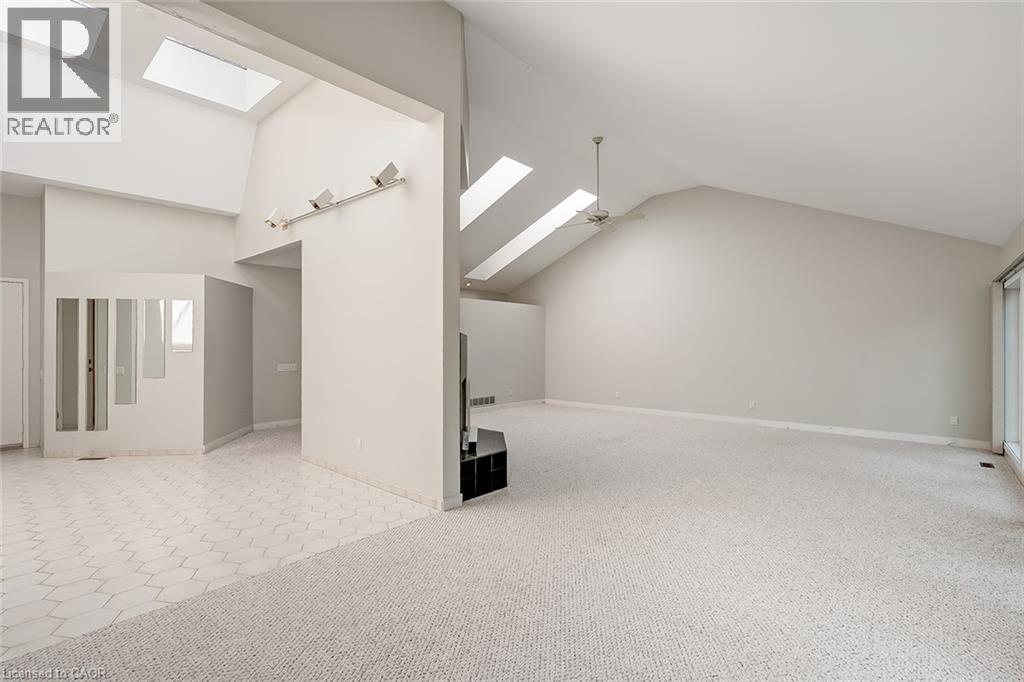 Vaulted ceilings with multiple skylights, track lighting, and a ceiling fan - 4189 Inglewood Drive, Burlington, ON - Photo Showing Other Room