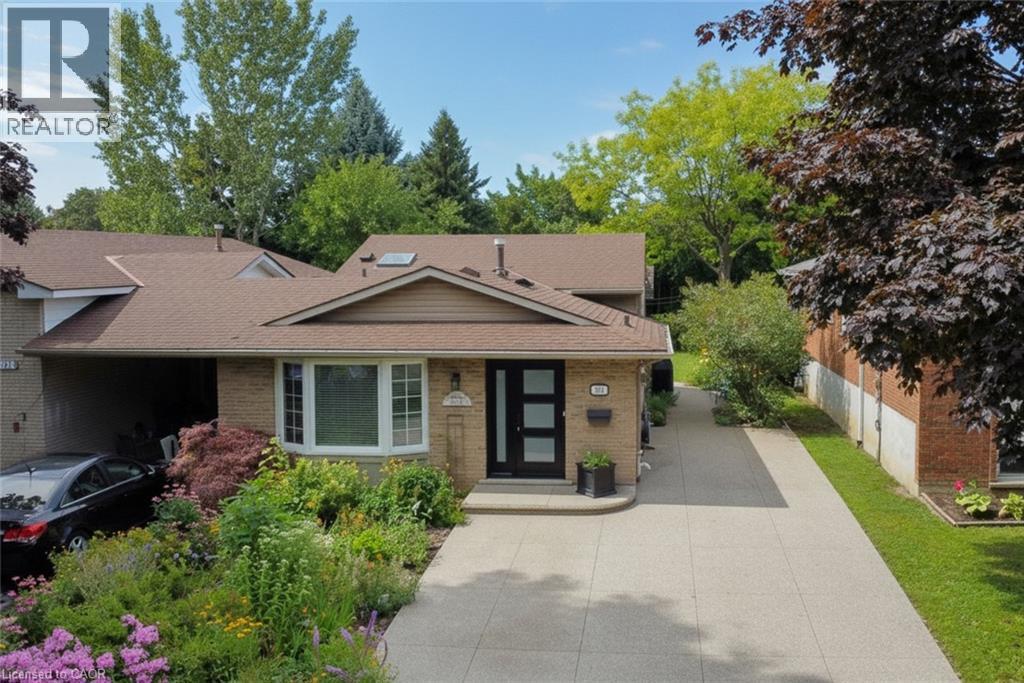 Welcoming brick façade with a modern front entry featuring dark framing and sidelights - 374 Brigadoon Drive, Hamilton, ON - Outdoor With Facade