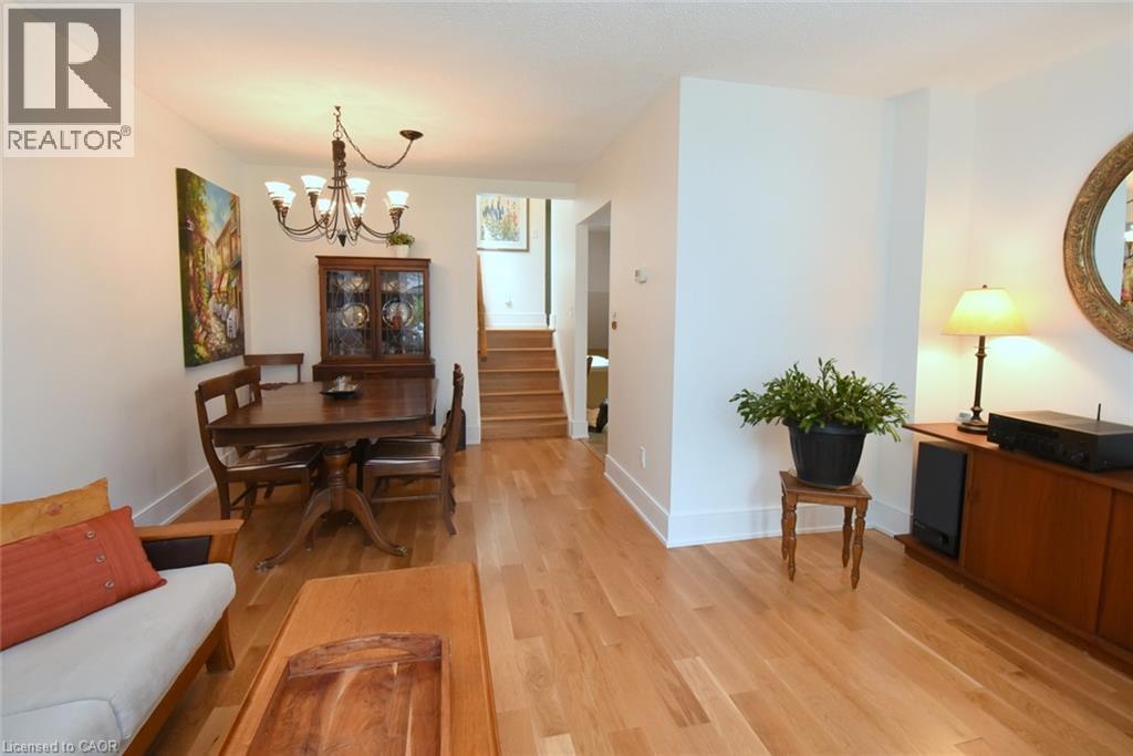 Hardwood flooring, white wall finishes, built-in staircase, and a chandelier lighting fixture - 374 Brigadoon Drive, Hamilton, ON - Indoor