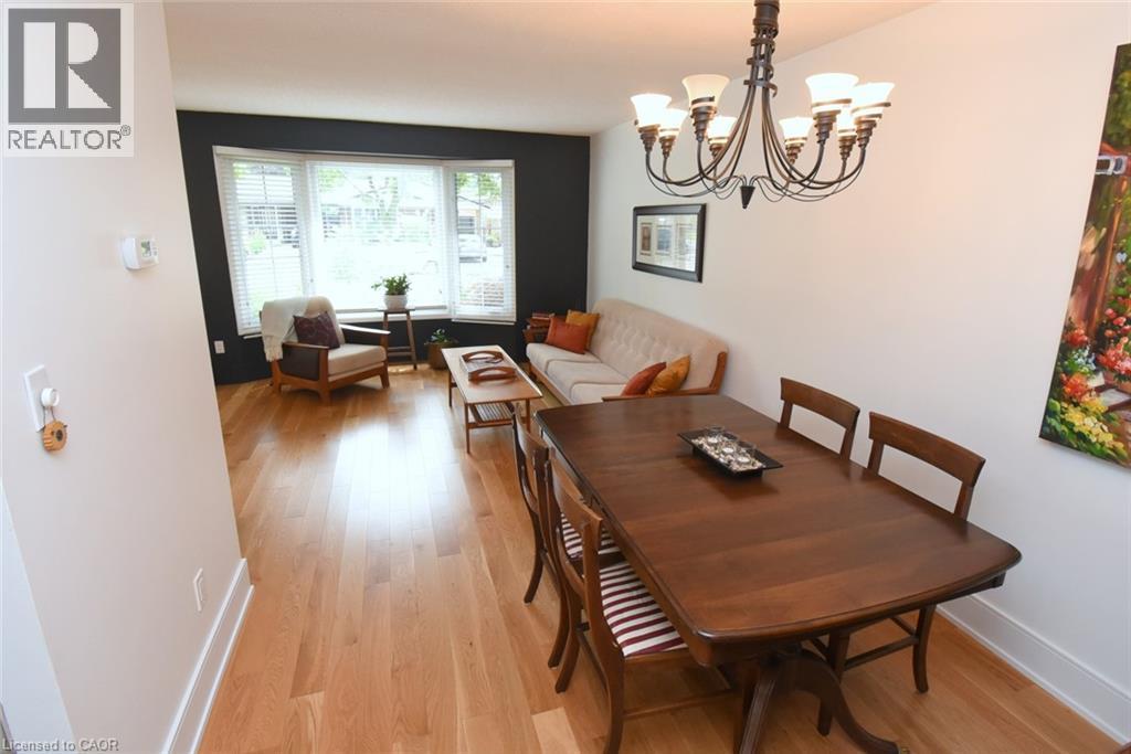 Hardwood flooring throughout, a dining area with a chandelier, and a living area featuring a bay window - 374 Brigadoon Drive, Hamilton, ON - Indoor Photo Showing Dining Room