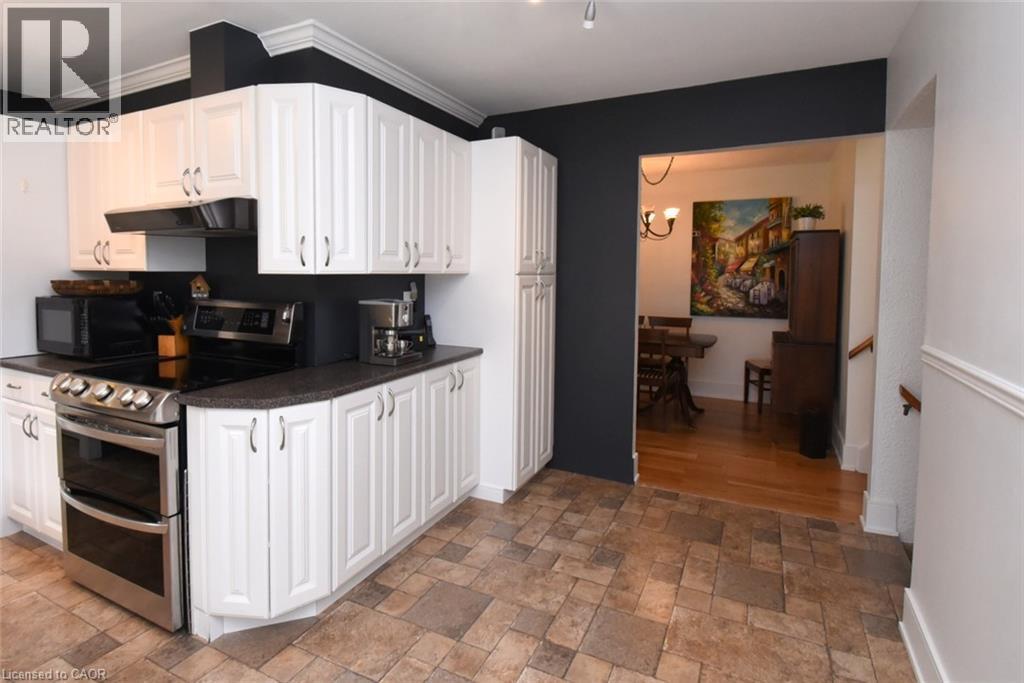 White cabinetry, stainless steel range, and tile flooring - 374 Brigadoon Drive, Hamilton, ON - Indoor Photo Showing Kitchen