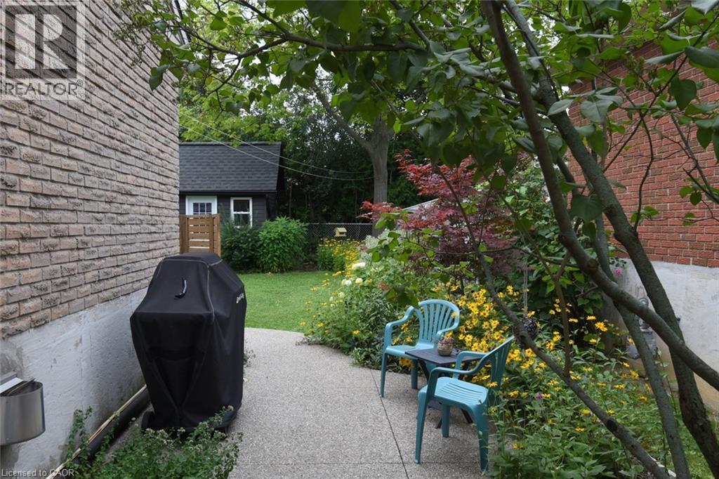 Brick exterior with a gravel pathway and mature landscaping - 374 Brigadoon Drive, Hamilton, ON - Outdoor