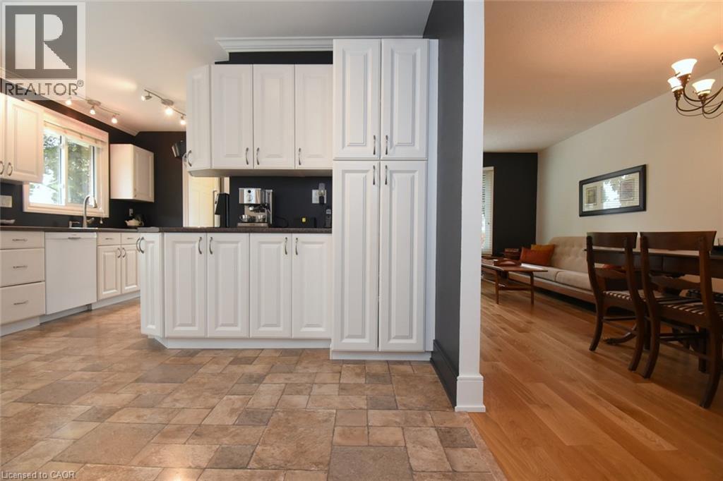 Kitchen featuring white cabinetry, dark countertops, and a stainless steel sink - 374 Brigadoon Drive, Hamilton, ON - Indoor Photo Showing Kitchen