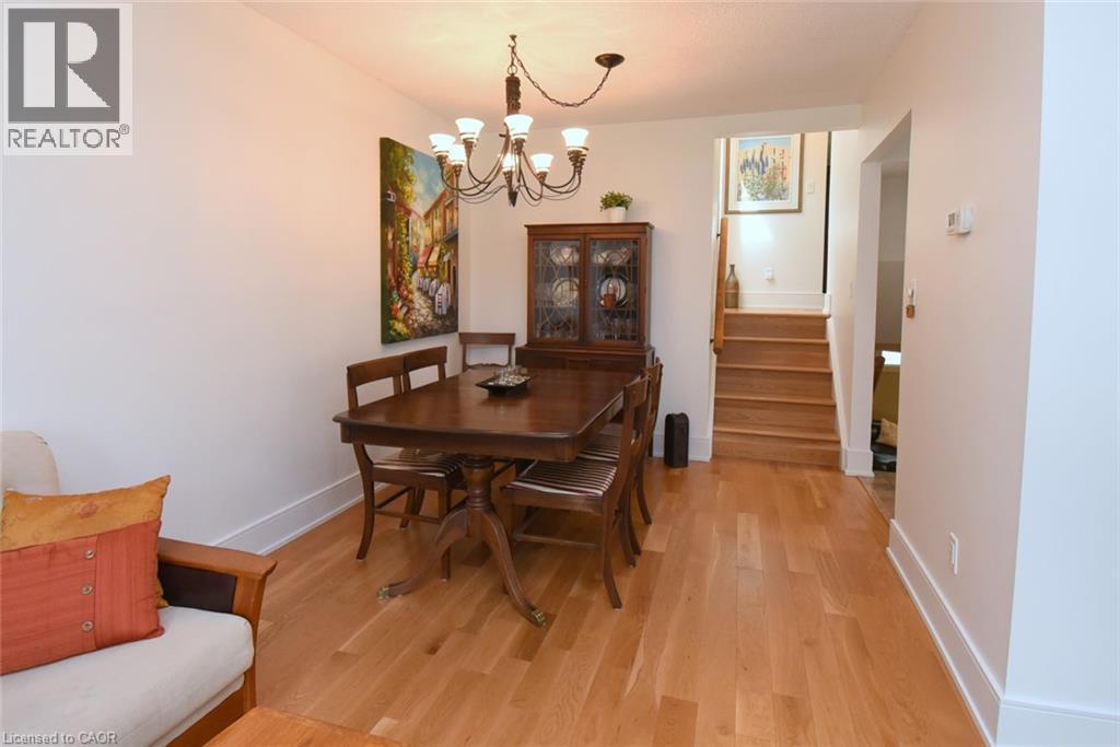 Hardwood flooring throughout, leading to a staircase with wood treads and handrail - 374 Brigadoon Drive, Hamilton, ON - Indoor Photo Showing Dining Room