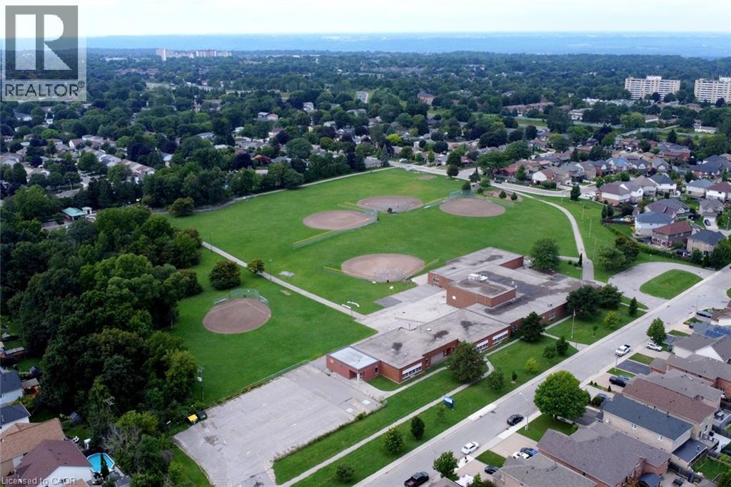 Extensive green space with multiple baseball diamonds, bordered by a paved pathway and mature trees - 374 Brigadoon Drive, Hamilton, ON - Outdoor With View