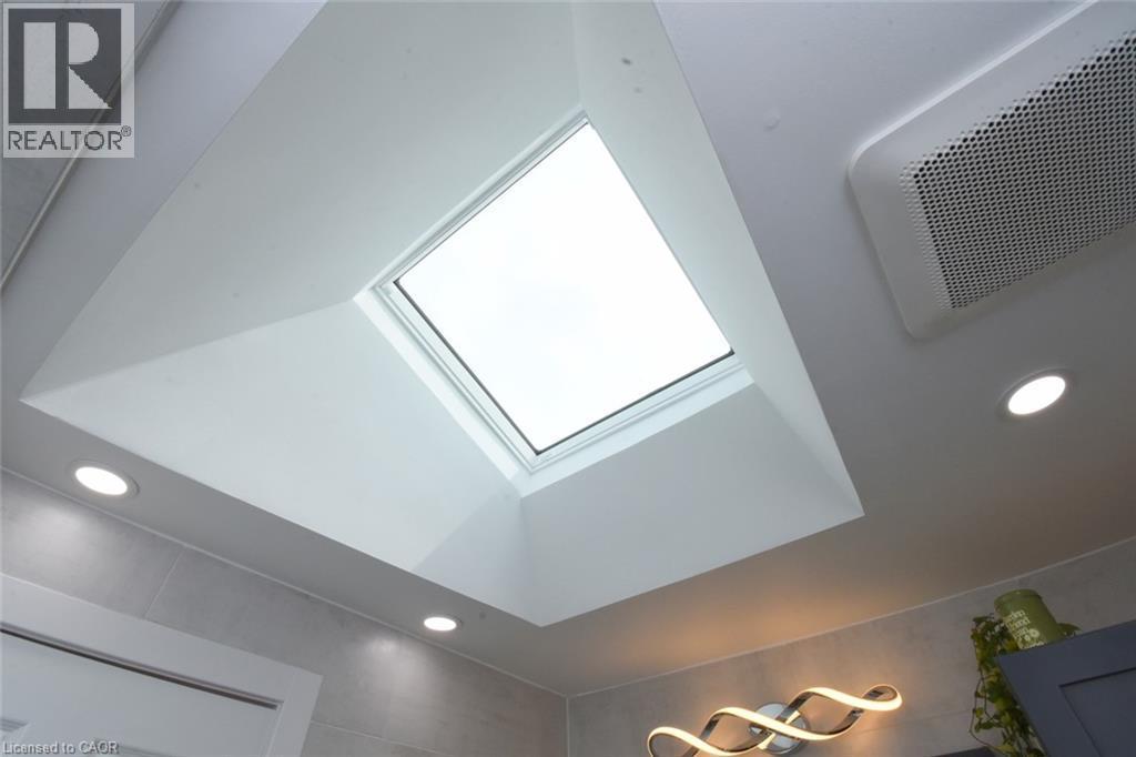 Recessed ceiling lighting, a skylight, and a contemporary wall-mounted light fixture - 374 Brigadoon Drive, Hamilton, ON - Indoor Photo Showing Other Room