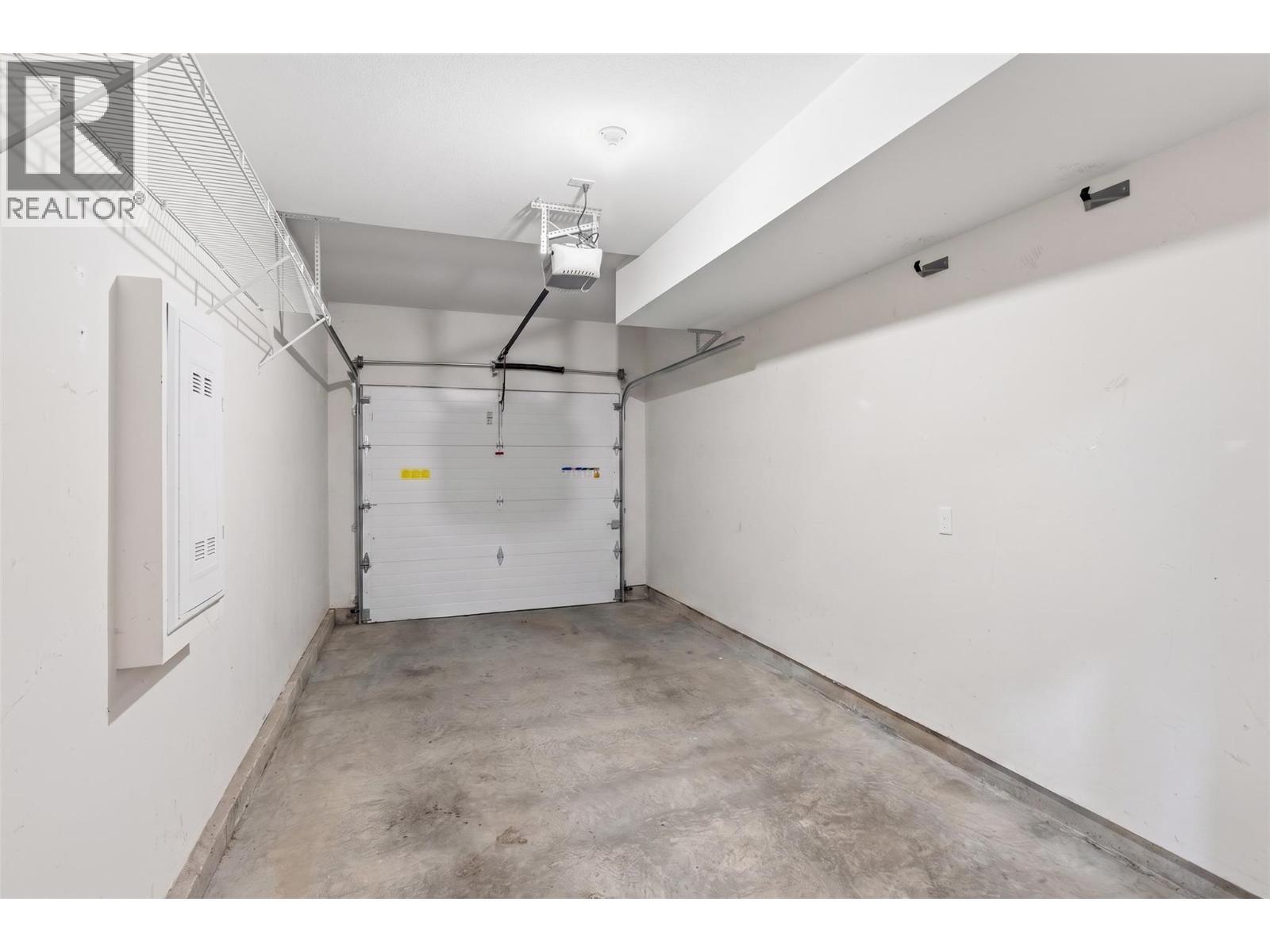 Single car garage (personal items/contents have been digitally removed from this photo) - 680 Old Meadows Road Unit# 74, Kelowna, BC - Indoor Photo Showing Garage