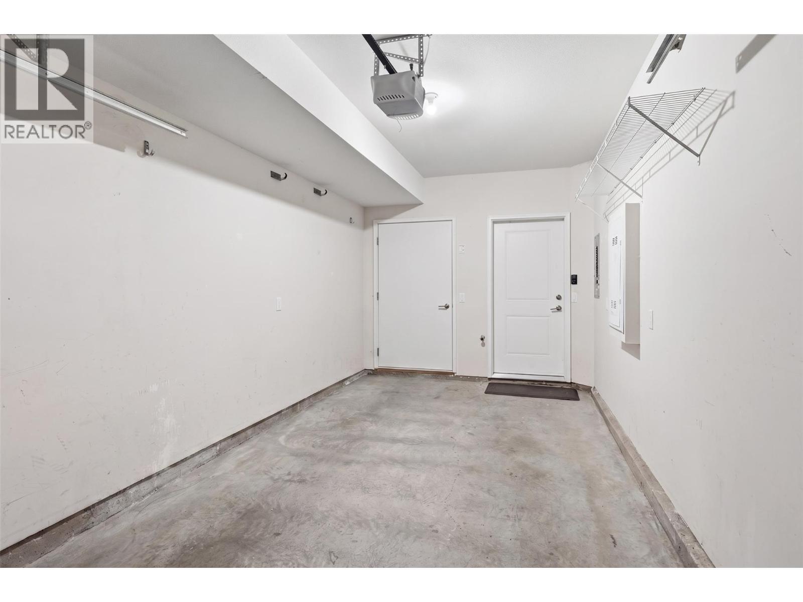 Attached single car garage - (personal contents have been digitally removed from this photo) - 680 Old Meadows Road Unit# 74, Kelowna, BC - Indoor
