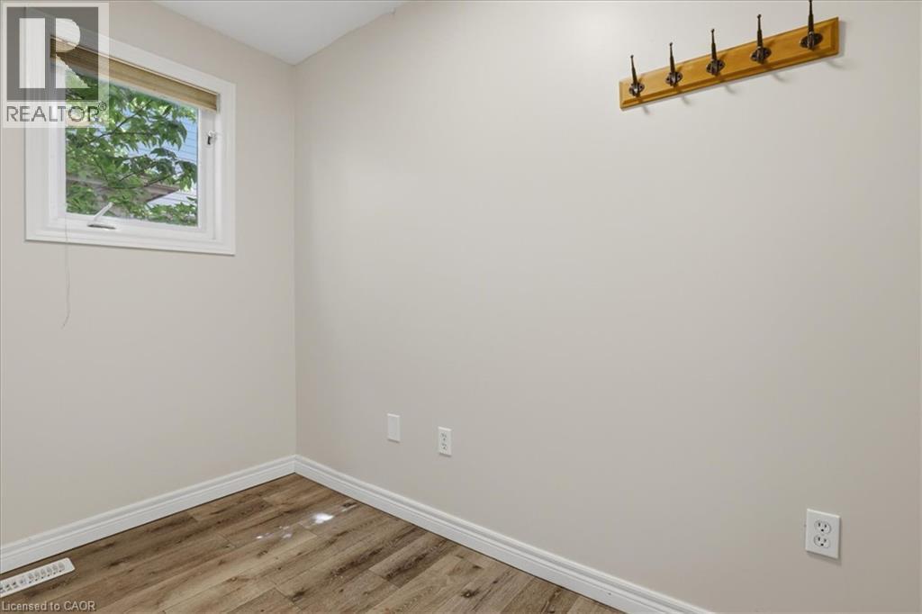 Bright, light-filled room with wood-finish flooring, white painted walls, and large window with natural light - 43 Decaro Crescent, Cambridge, ON - Indoor Photo Showing Other Room