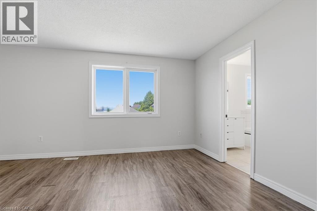 Bright, light-filled bedroom featuring expansive windows with natural light, wood-finish flooring throughout, and direct access to an adjoining space via a white interior door - 43 Decaro Crescent, Cambridge, ON - Indoor Photo Showing Other Room
