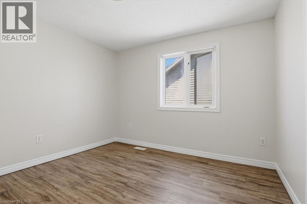 Wood-finish flooring, white trim, and a white-framed window - 43 Decaro Crescent, Cambridge, ON - Indoor Photo Showing Other Room