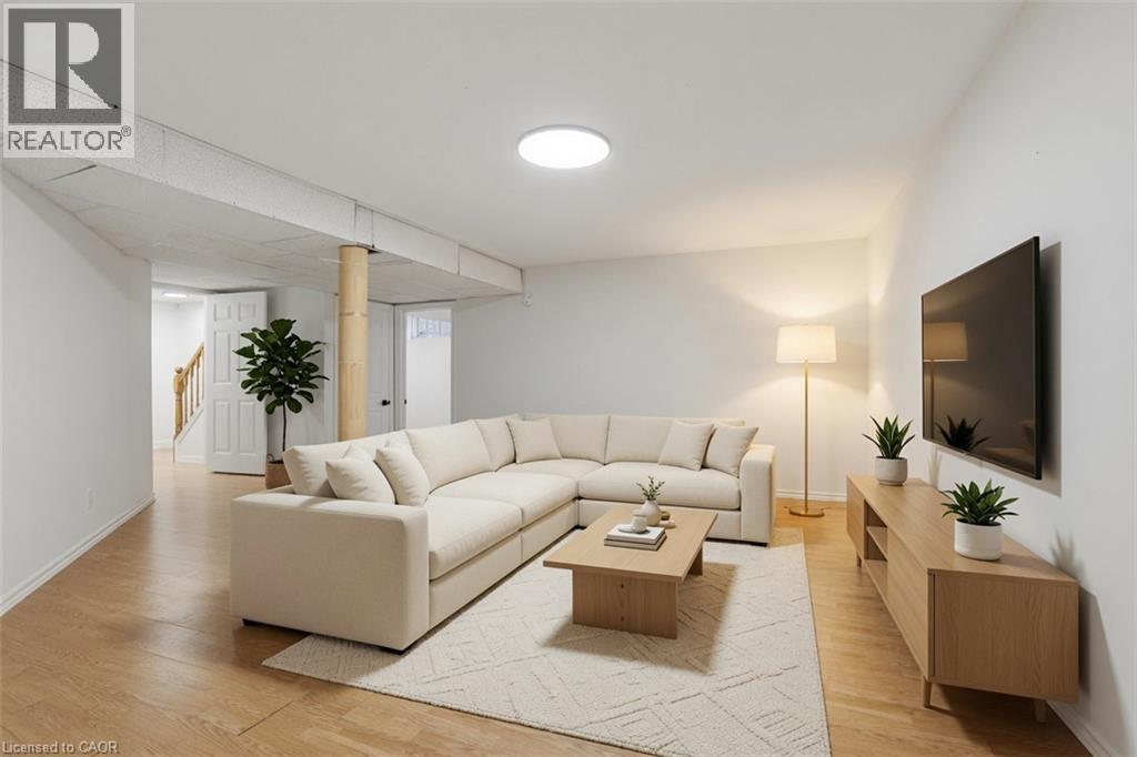 Light wood-finish flooring, white walls, and a large circular flush-mount ceiling light - 43 Decaro Crescent, Cambridge, ON - Indoor Photo Showing Living Room