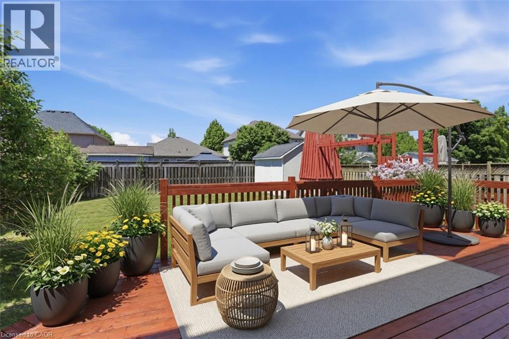 Expansive composite deck featuring multiple levels in warm wood tones, anchored by a built-in wooden sectional with cushioned seating and a wood-finish coffee table - 43 Decaro Crescent, Cambridge, ON - Outdoor With Deck Patio Veranda