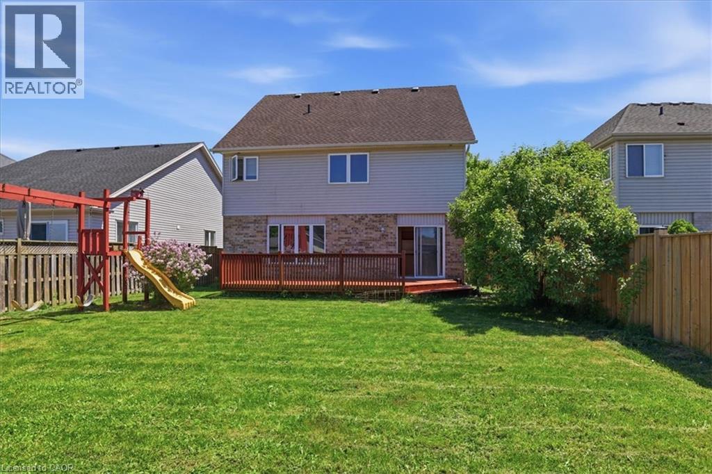 Expansive backyard with a manicured lawn, wood fencing, and a built-in wood deck - 43 Decaro Crescent, Cambridge, ON - Outdoor With Deck Patio Veranda