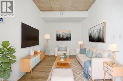 High ceilings with exposed concrete, wood-finish flooring, and white painted walls - 