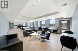 Spacious common area featuring recessed lighting, large windows, a built-in kitchen, and wood-finish flooring - 