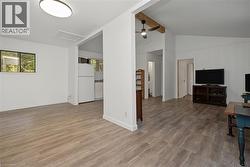 Wood-finish flooring throughout, vaulted ceiling with exposed beam, and a ceiling fan - 