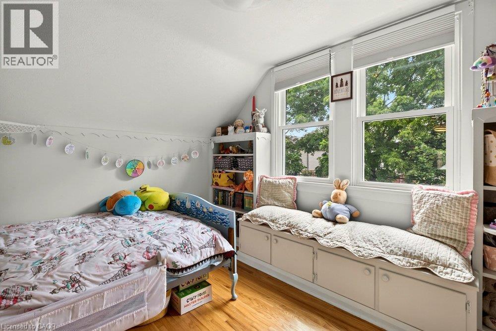 Hardwood flooring, dual pane windows, built-in window seat with storage, sloped ceiling, built-in shelving - 23 Kipling Road, Hamilton, ON - Indoor Photo Showing Bedroom