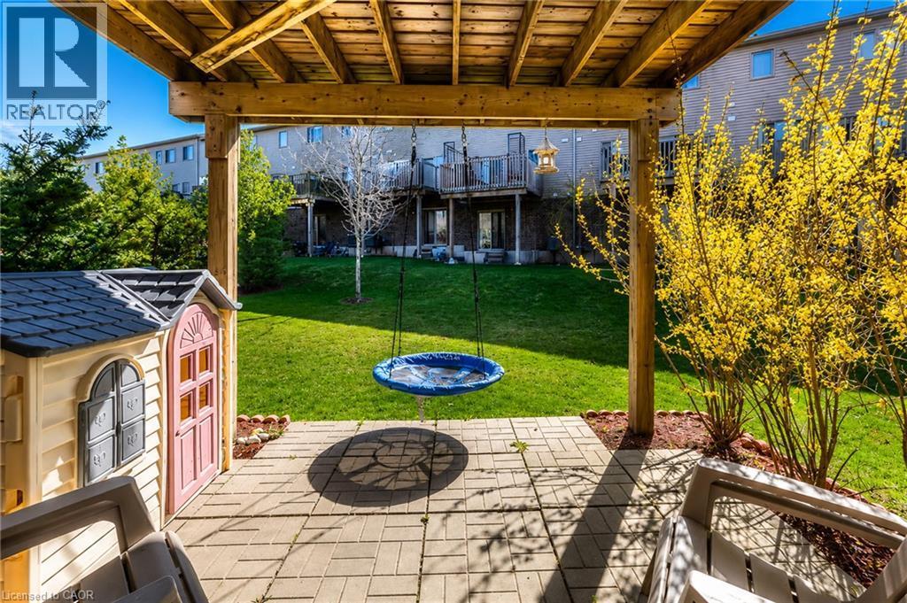 Expansive backyard oasis featuring a paver patio beneath a wooden pergola, manicured lawn, and mature landscaping with flowering shrubs - 750 Lawrence Street Unit# 86, Cambridge, ON - Outdoor With Deck Patio Veranda