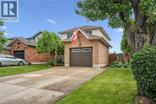 Brick and siding exterior with an attached garage, paved driveway, and established landscaping - 817 Acadia Drive, Hamilton, ON - Outdoor