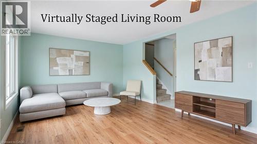 Bright living area with wood-finish flooring, a ceiling fan, and a staircase featuring a wooden handrail - 817 Acadia Drive, Hamilton, ON - Indoor