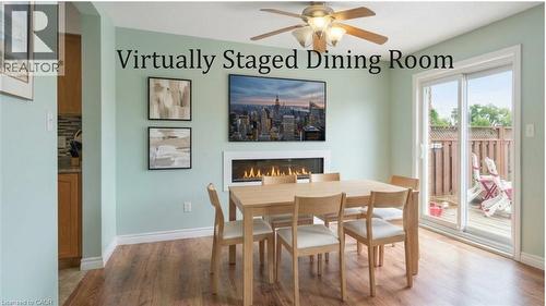 Wood-finish flooring, built-in fireplace, ceiling fan with integrated lighting, and sliding glass door - 817 Acadia Drive, Hamilton, ON - Indoor Photo Showing Dining Room