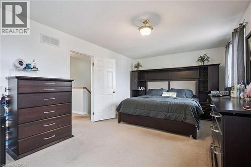 Neutral wall color, carpeted flooring, white trim, and a ceiling-mounted light fixture - 817 Acadia Drive, Hamilton, ON - Indoor Photo Showing Bedroom