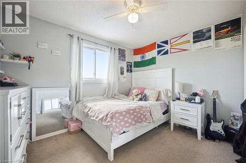 Carpeted flooring, white trim window, and ceiling fan with integrated lighting - 817 Acadia Drive, Hamilton, ON - Indoor Photo Showing Bedroom