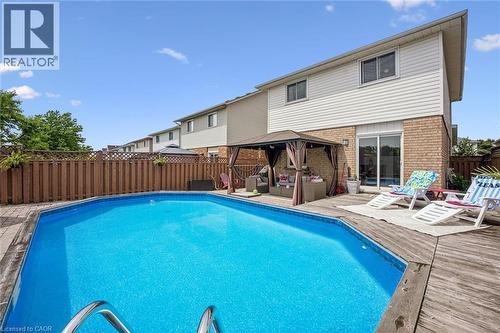 Backyard featuring an inground swimming pool, wood deck, and a privacy fence - 817 Acadia Drive, Hamilton, ON - Outdoor With In Ground Pool With Deck Patio Veranda