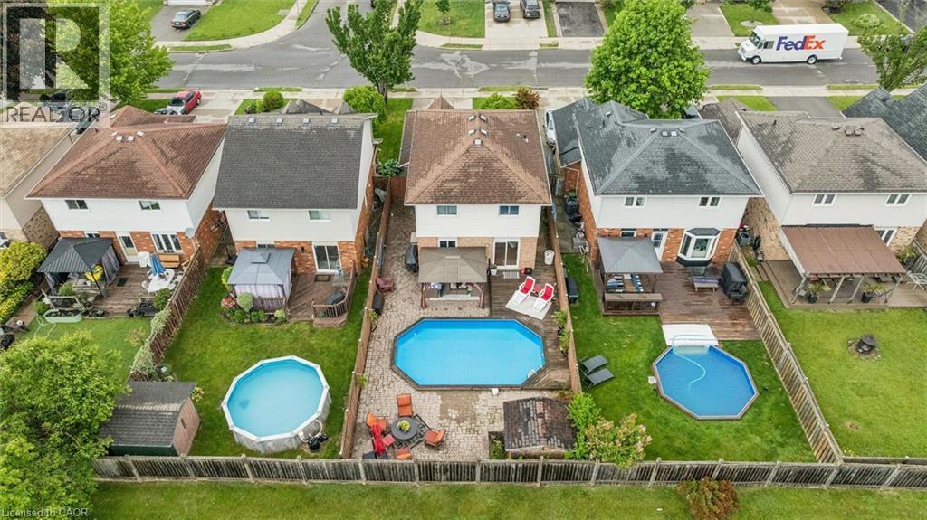 Rear exterior with a wood-finish deck, an in-ground swimming pool, and a fenced yard - 817 Acadia Drive, Hamilton, ON - Outdoor With Above Ground Pool With View