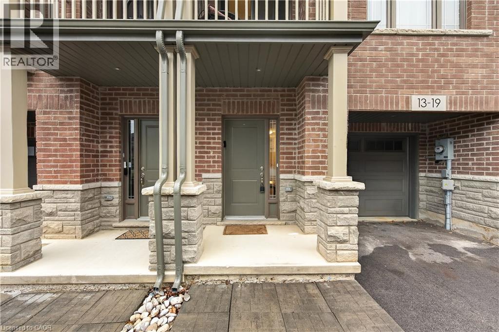 Brick and stone exterior with covered front porch, integrated garage, and a wood-finish pathway - 19 Picardy Drive Unit# 13, Hamilton, ON - Outdoor