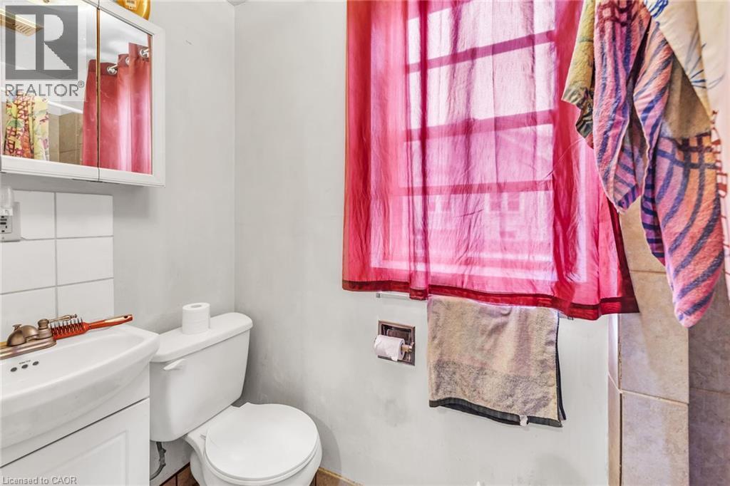 Bathroom with white wall tile, pedestal sink, and mounted medicine cabinet - 1367 Cannon Street E, Hamilton, ON - Indoor Photo Showing Bathroom