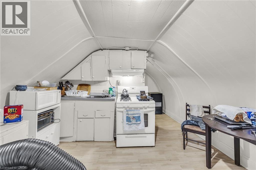 Compact kitchen with white cabinetry, a single basin sink, and a white gas range - 1367 Cannon Street E, Hamilton, ON - Indoor