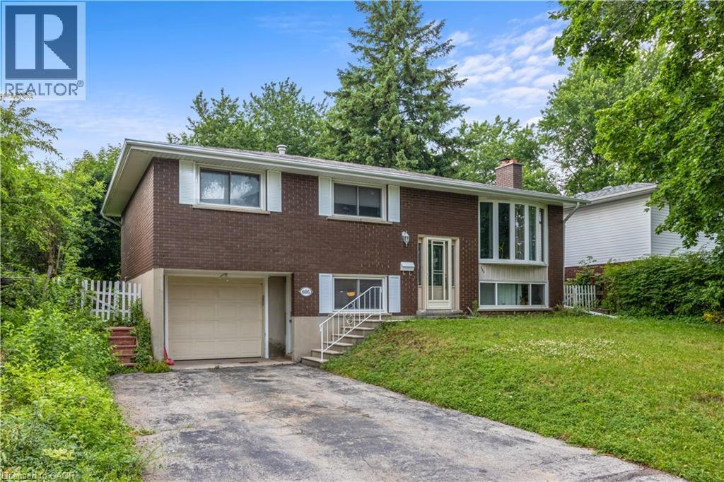Brick split-level home featuring a two-car attached garage, multiple windows providing natural light, and a sloped driveway - 695 Glen Forrest Boulevard Unit# Upper, Waterloo, ON - Outdoor