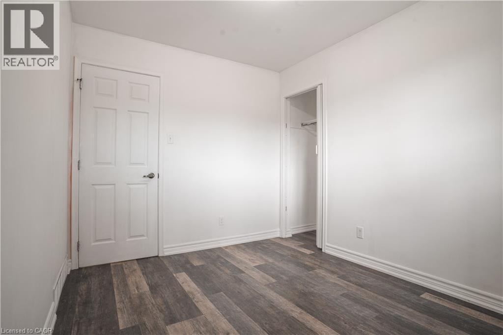Bright, neutral bedroom featuring hardwood-finish flooring, clean white walls, and ample natural light - 695 Glen Forrest Boulevard Unit# Upper, Waterloo, ON - Indoor Photo Showing Other Room
