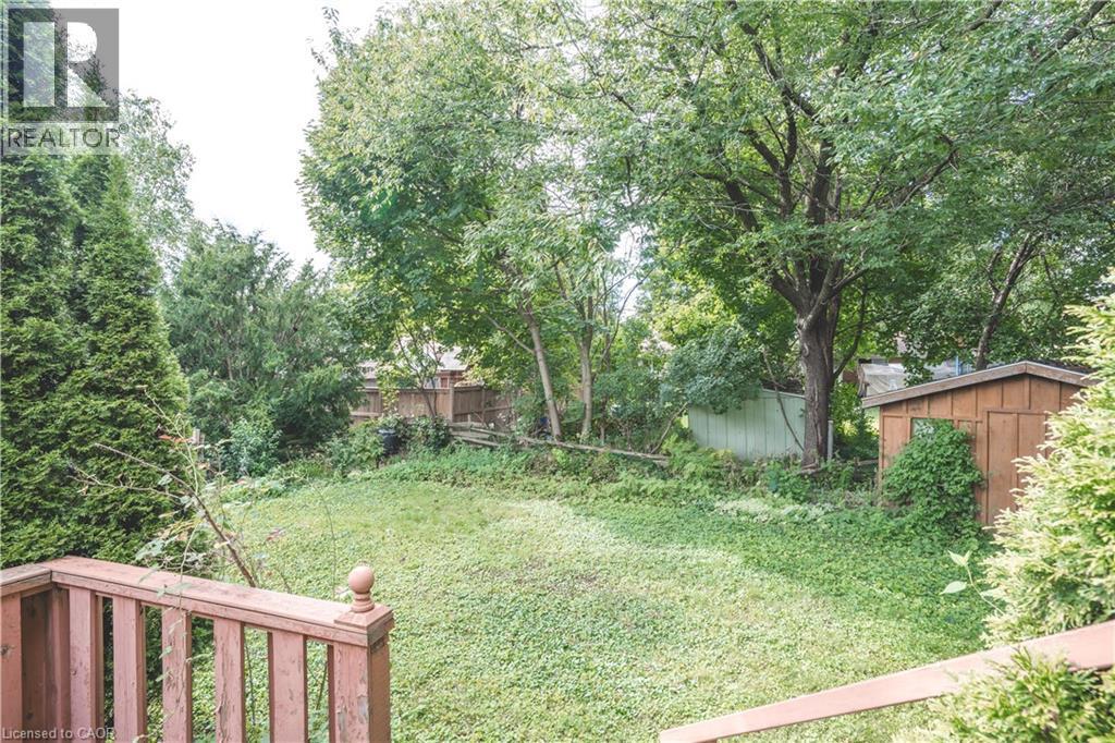 Expansive backyard with a wooden deck, mature trees, and a storage shed - 695 Glen Forrest Boulevard Unit# Upper, Waterloo, ON - Outdoor