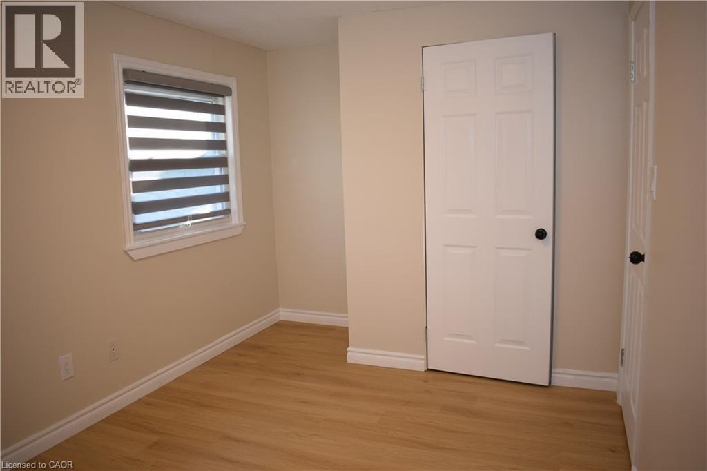 Neutral tone wall paint with wood-finish flooring - 655 Albert Street Unit# A, Waterloo, ON - Indoor Photo Showing Other Room