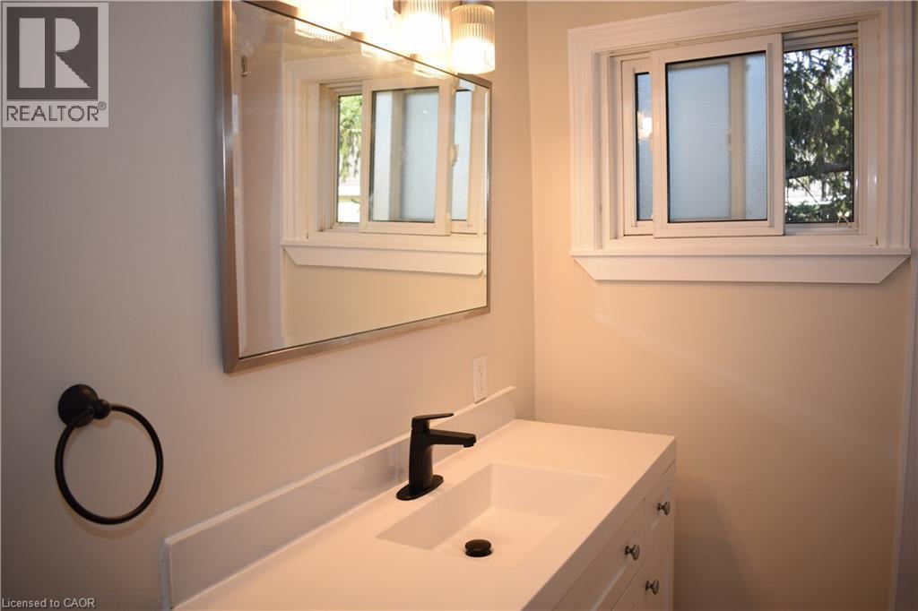 Modern vanity with an integrated sink, matte black faucet, and sleek hardware - 655 Albert Street Unit# A, Waterloo, ON - Indoor Photo Showing Bathroom