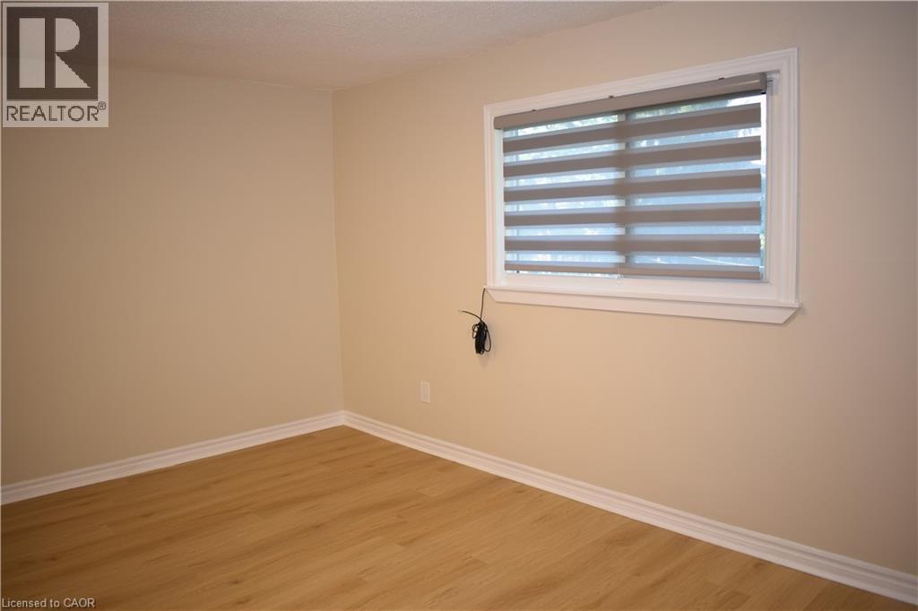 Light-toned walls, wood-finish flooring, white window trim, and white baseboards - 655 Albert Street Unit# A, Waterloo, ON - Indoor Photo Showing Other Room