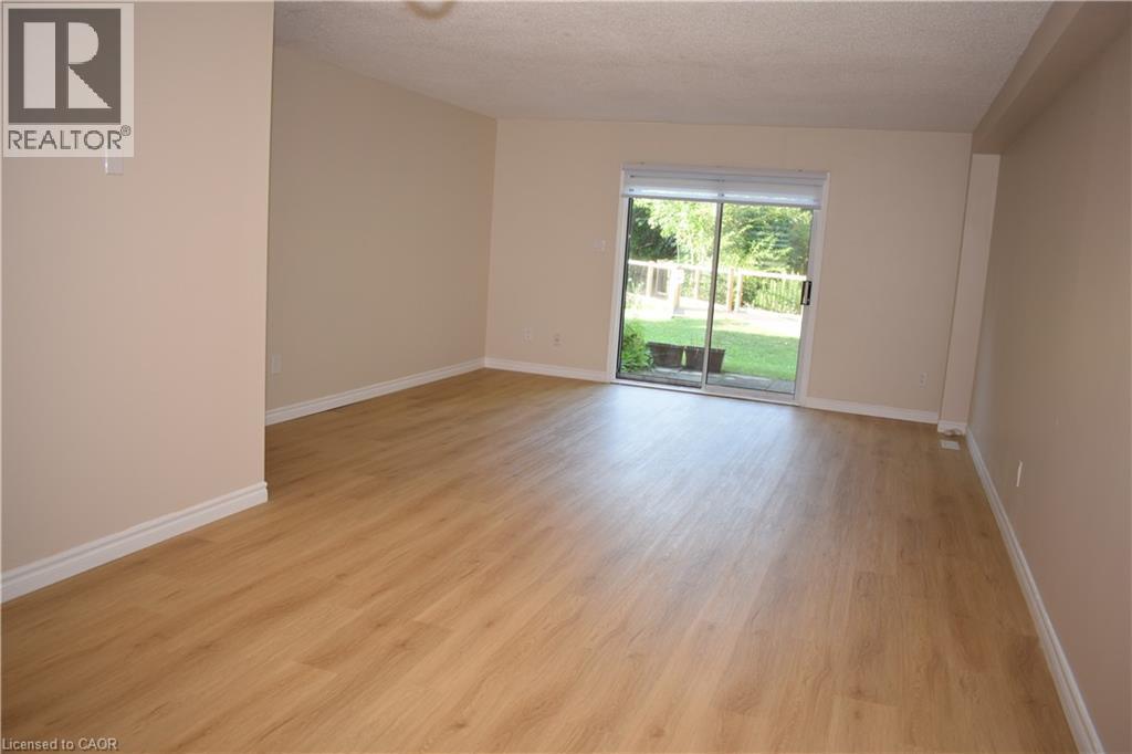 Wood-finish flooring, neutral wall tones, and sliding glass door - 655 Albert Street Unit# A, Waterloo, ON - Indoor Photo Showing Other Room