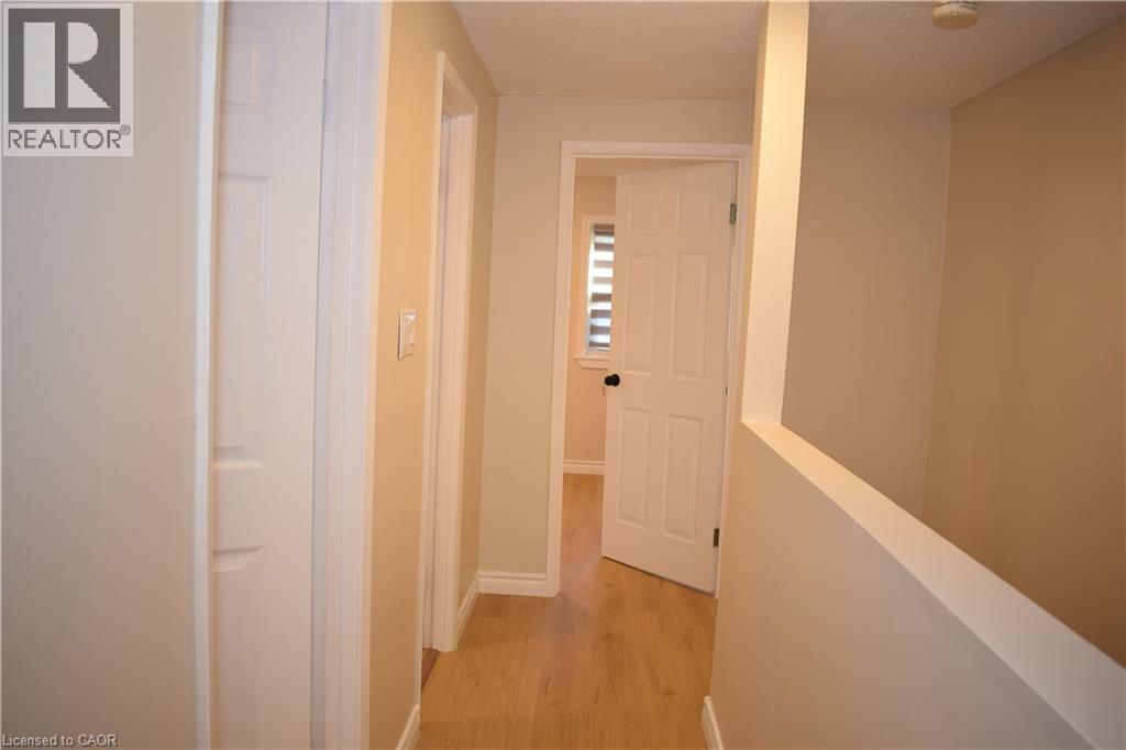 Light-toned wood-finish flooring, neutral wall tones, and white paneled doors - 655 Albert Street Unit# A, Waterloo, ON - Indoor Photo Showing Other Room