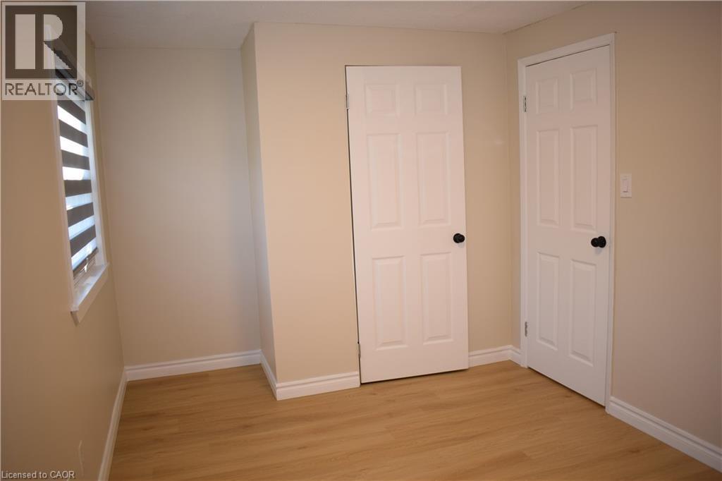 Light wood-finish flooring with neutral wall paint - 655 Albert Street Unit# A, Waterloo, ON - Indoor Photo Showing Other Room