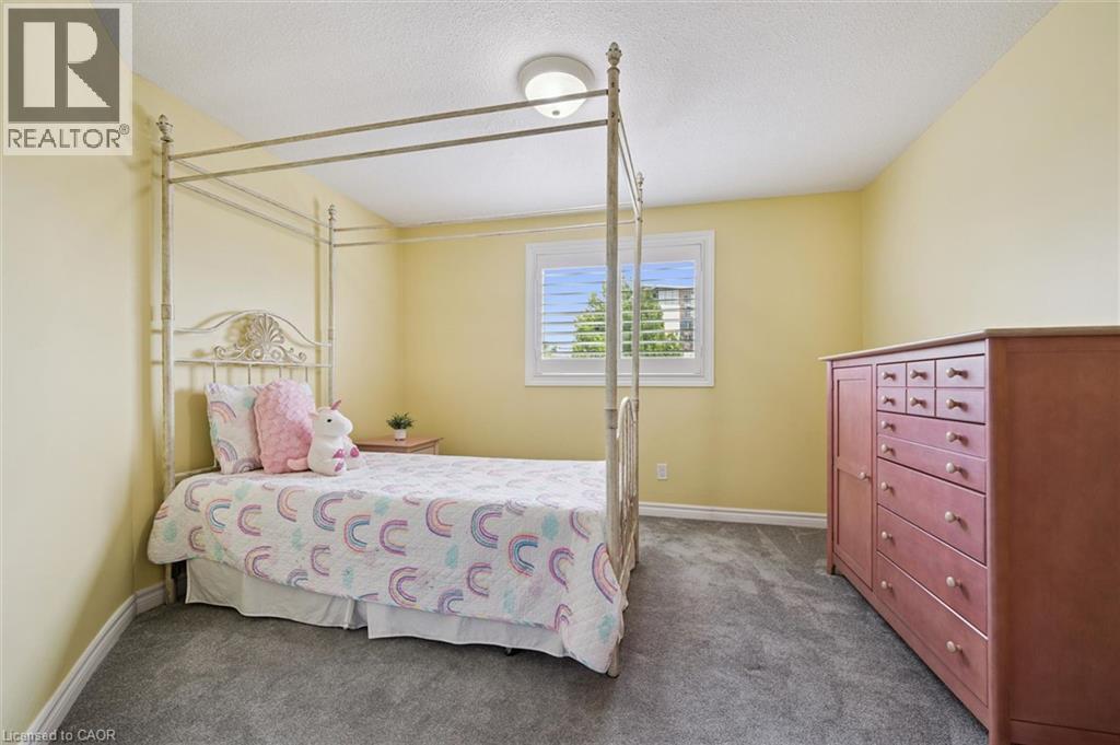 Carpeted room featuring a single window with white shutters, a flush-mount ceiling light, and light-colored walls - 60 Elmsdale Drive Unit# 25, Kitchener, ON - Indoor Photo Showing Bedroom