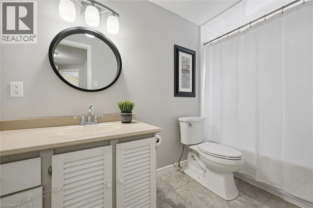 Vanity with a single basin sink, chrome faucet, and louvered cabinet doors - 60 Elmsdale Drive Unit# 25, Kitchener, ON - Indoor Photo Showing Bathroom