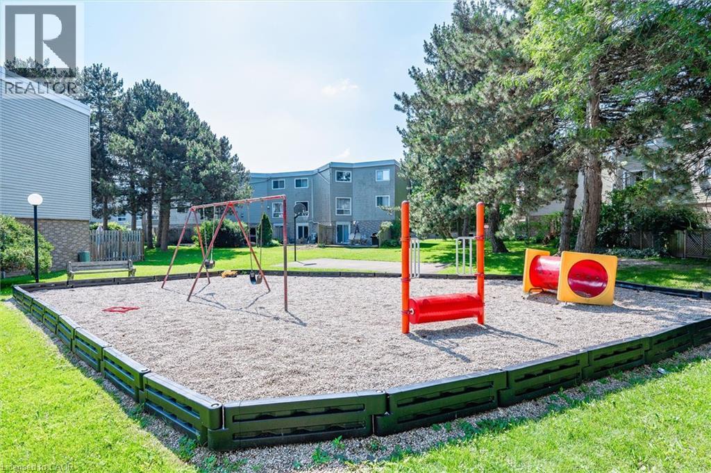 Outdoor play area featuring a swing set, climbing structure, and tunnel - 60 Elmsdale Drive Unit# 25, Kitchener, ON - Outdoor