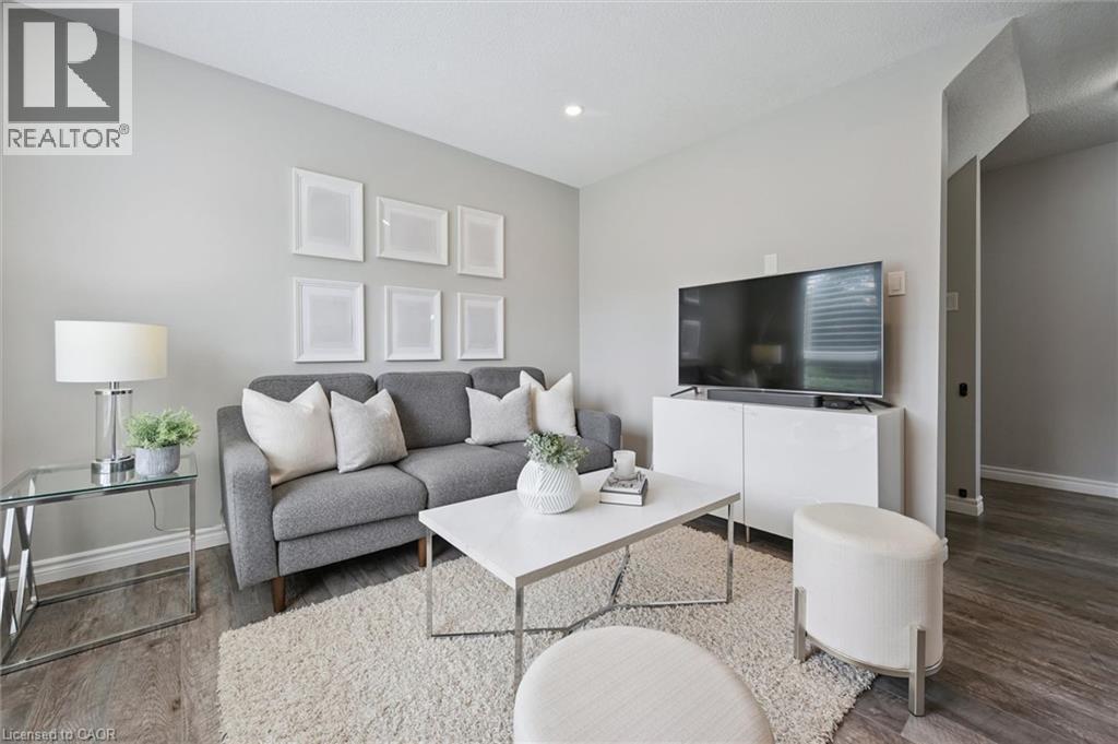 Recessed ceiling lighting, light gray wall finishes, and wood-finish flooring - 60 Elmsdale Drive Unit# 25, Kitchener, ON - Indoor Photo Showing Living Room