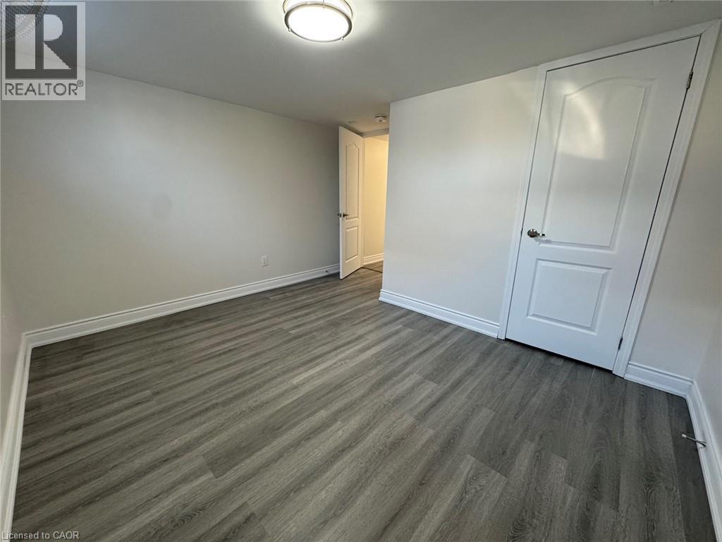 Spacious bedroom offering neutral walls, wood-finish plank flooring, and abundant natural light - 15 Pinecrest Drive Unit# Lower, Kitchener, ON - Indoor Photo Showing Other Room