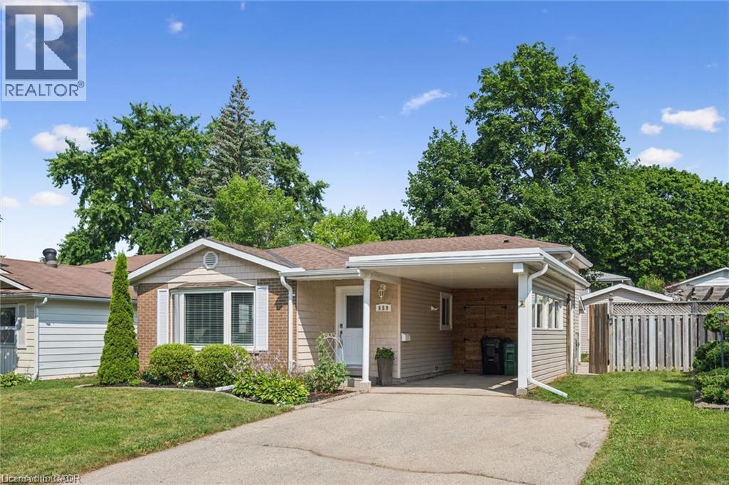 Single-story residence featuring a carport, a paved driveway, and mature landscaping - 659 Glen Forrest Boulevard, Waterloo, ON - Outdoor With Facade